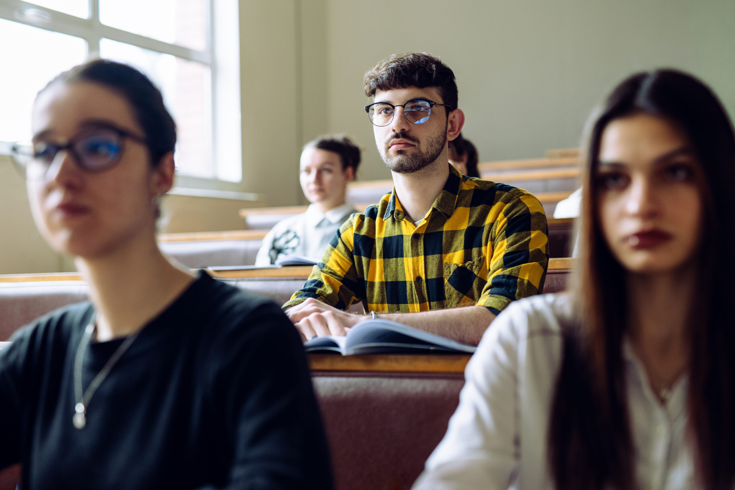 Group of young college students attending a lecture in lecture hall.