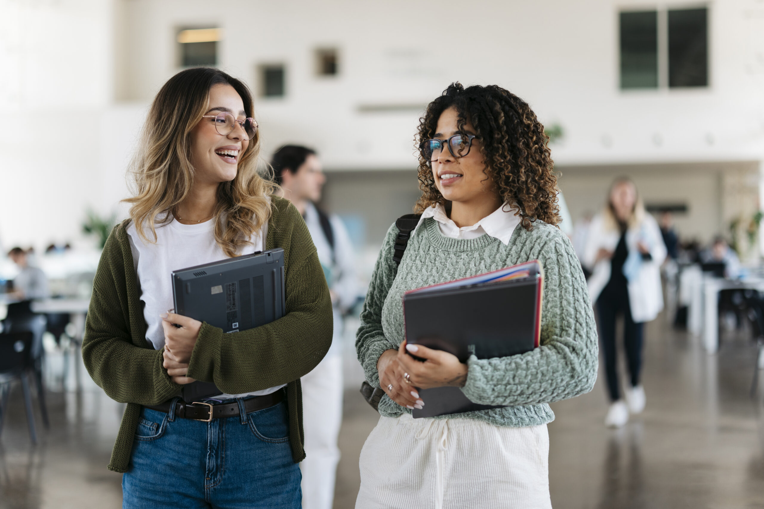 Two female students walking together in a modern university building